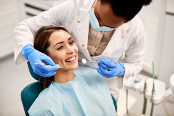 Woman smiling in dentist chair at Claregate Dental consultation